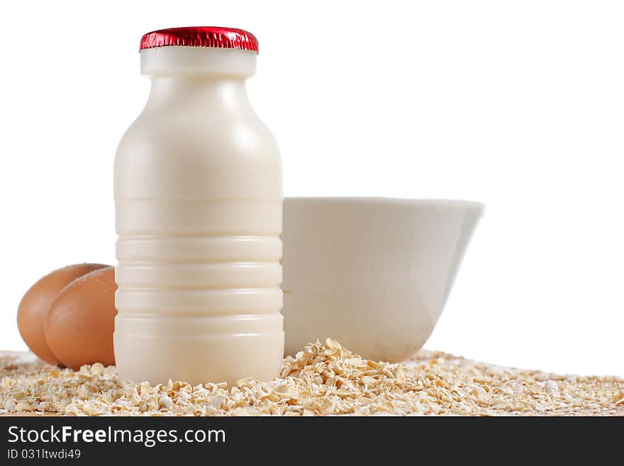 A bottle of milk, eggs and oatmeal on the table. A bottle of milk, eggs and oatmeal on the table