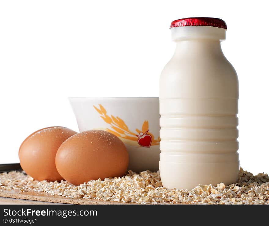 A bottle of milk, eggs and oatmeal on the wooden surface. A bottle of milk, eggs and oatmeal on the wooden surface