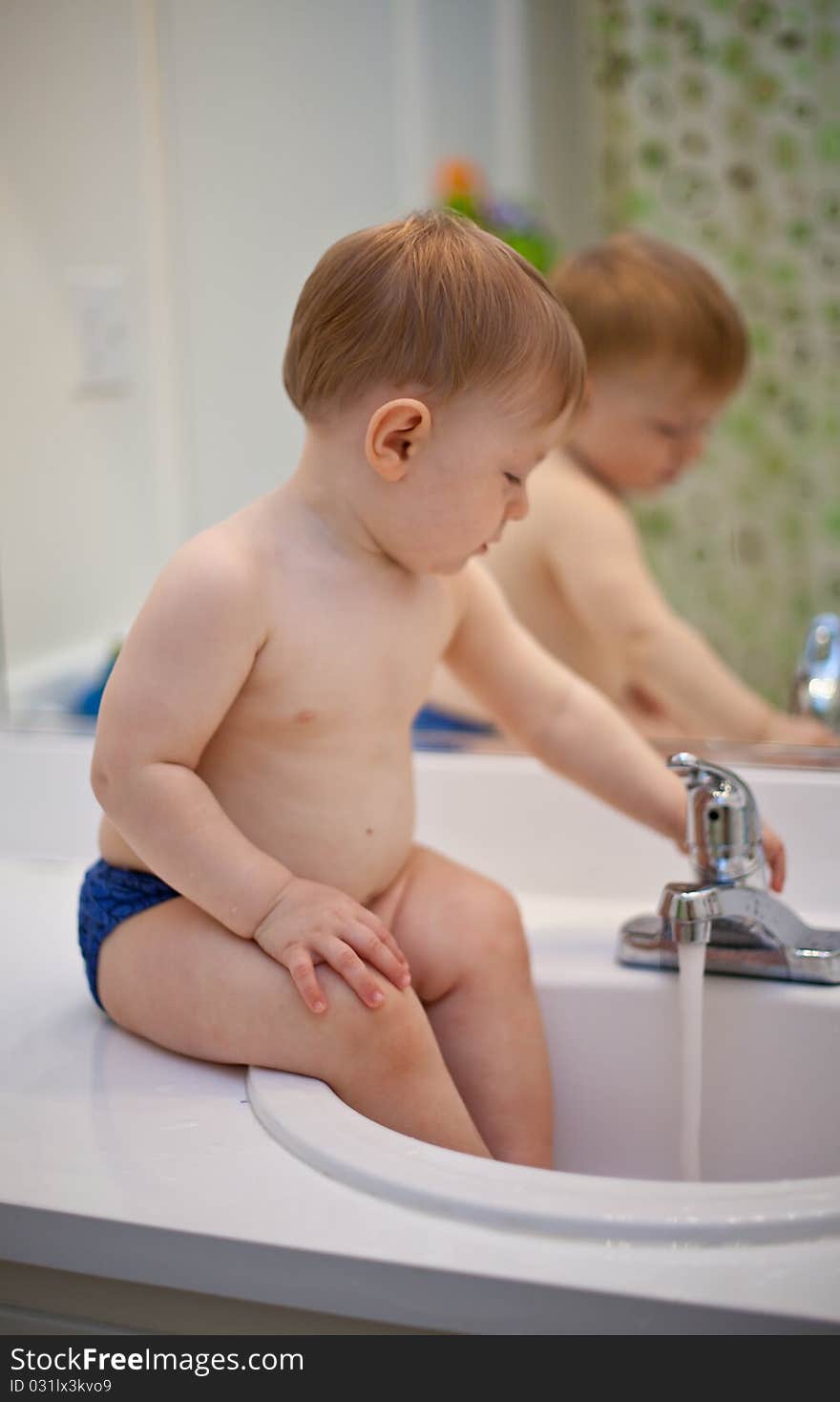 Cute baby boy playing with water