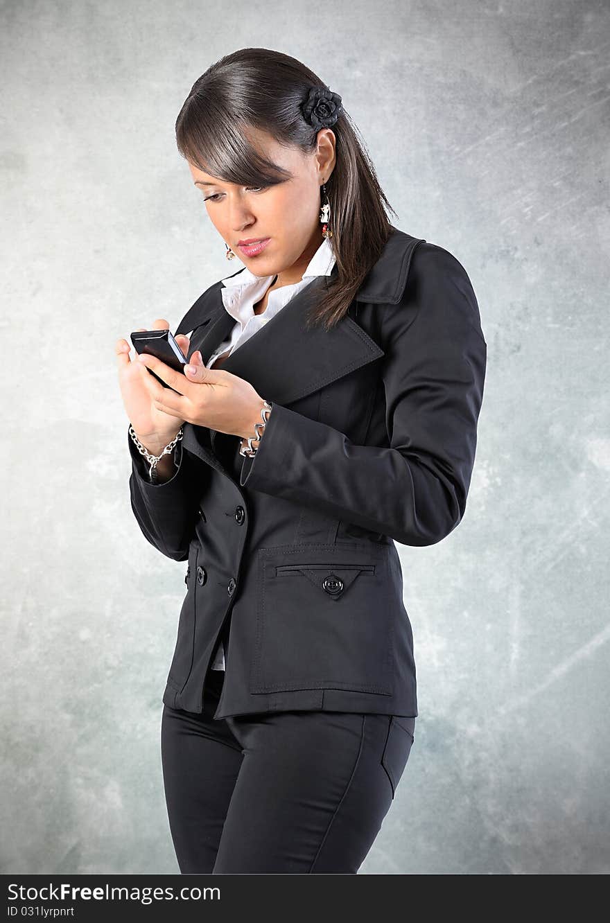 Woman is writing/readind a sms on a phone. Grounge background. Woman is writing/readind a sms on a phone. Grounge background