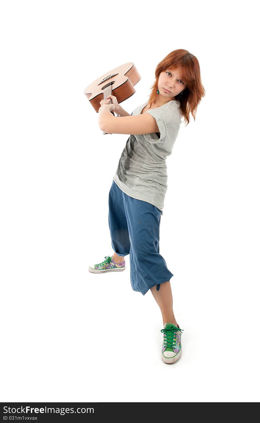 Girl smashing a guitar. Isolated on white