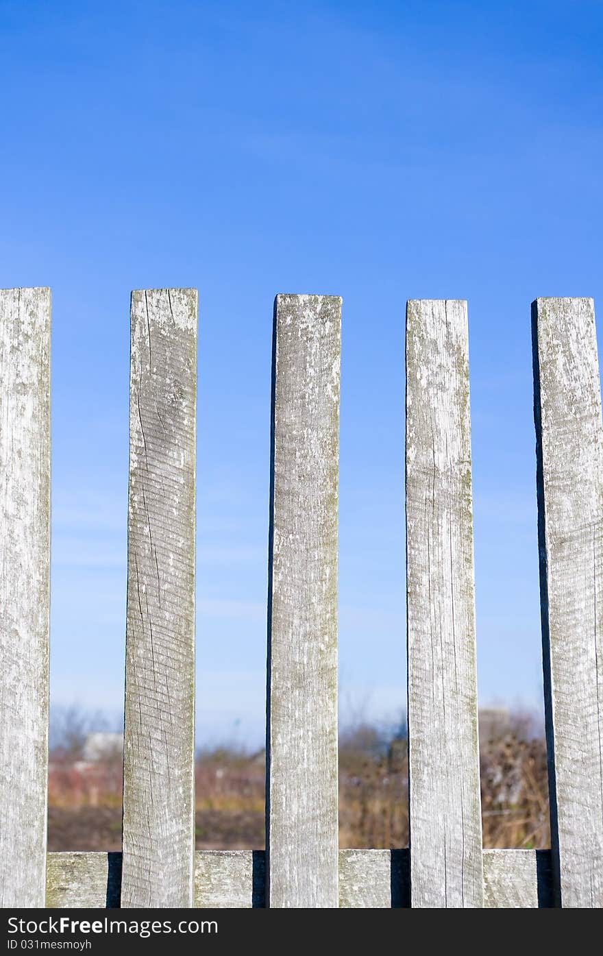 A grapesteak fence in green grass under a blue sky. A grapesteak fence in green grass under a blue sky.