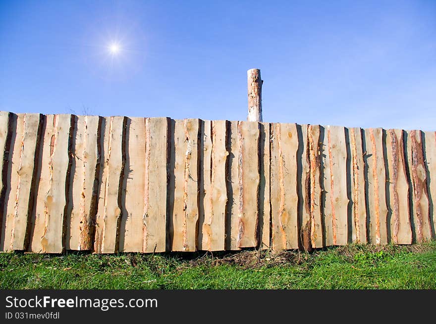 A grapesteak fence in green grass under a blue sky. A grapesteak fence in green grass under a blue sky.