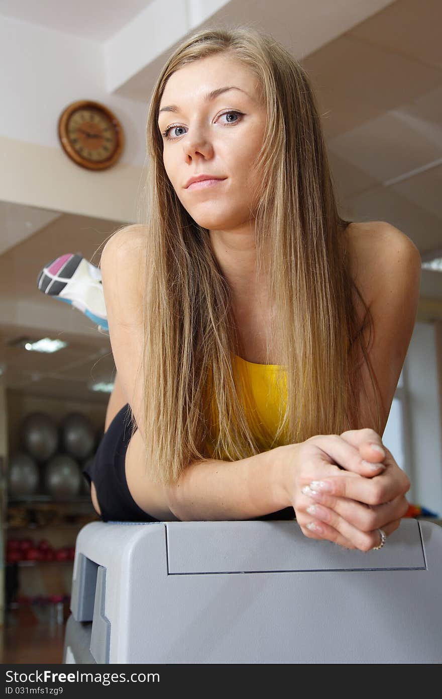 Beautiful Blonde girl sitting on steps in gym