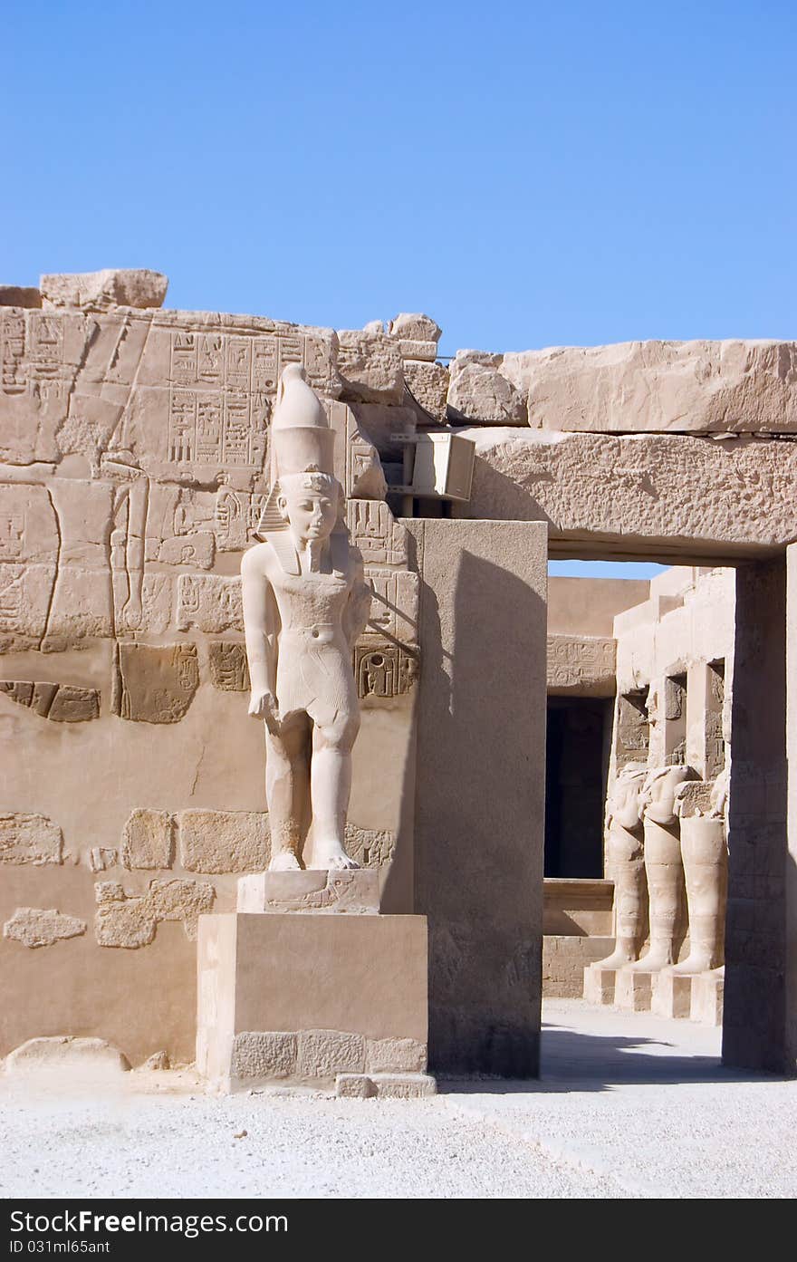 Ancient Pharaoh statue and column on backlighted sky background