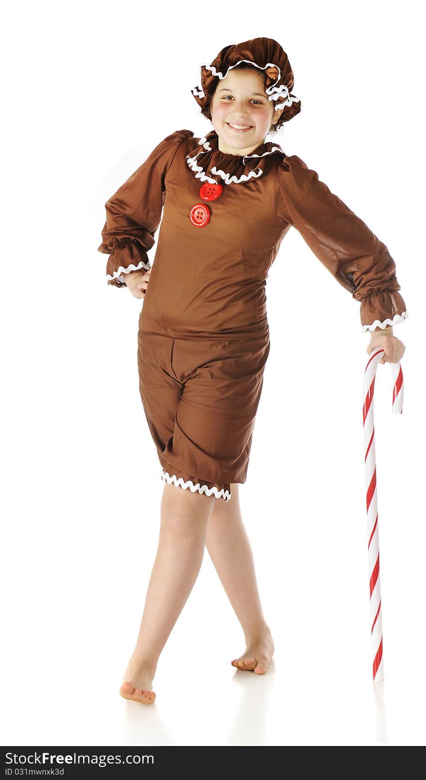 A cute preteen gingerbread girl leaning on a giant candy cane. Isolated on white. A cute preteen gingerbread girl leaning on a giant candy cane. Isolated on white.