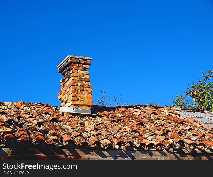 Old tiled roof with small chimney on it. Old tiled roof with small chimney on it