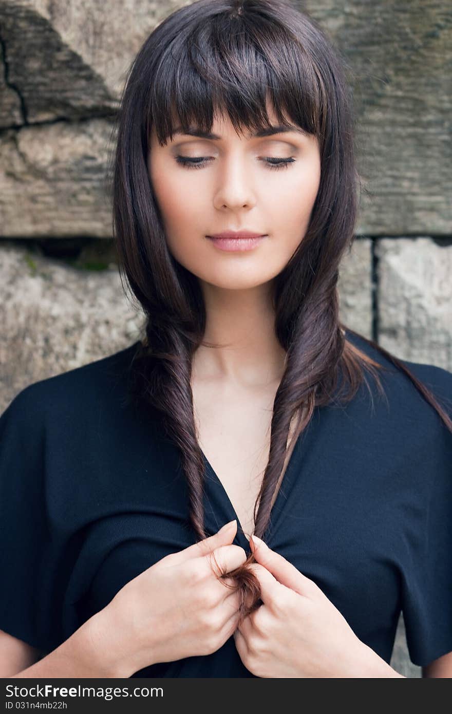 Young beautiful girl the brunette, holds hair