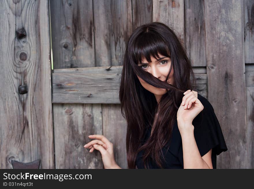 Young beautiful girl the brunette, holds hair