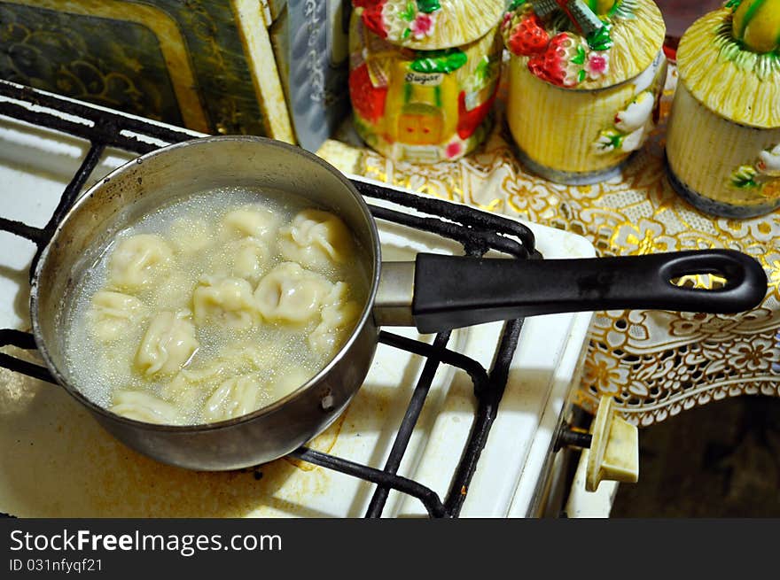 Dumplings cooked in a ladle-drenched juicy soup on a gas cooker. Dumplings cooked in a ladle-drenched juicy soup on a gas cooker