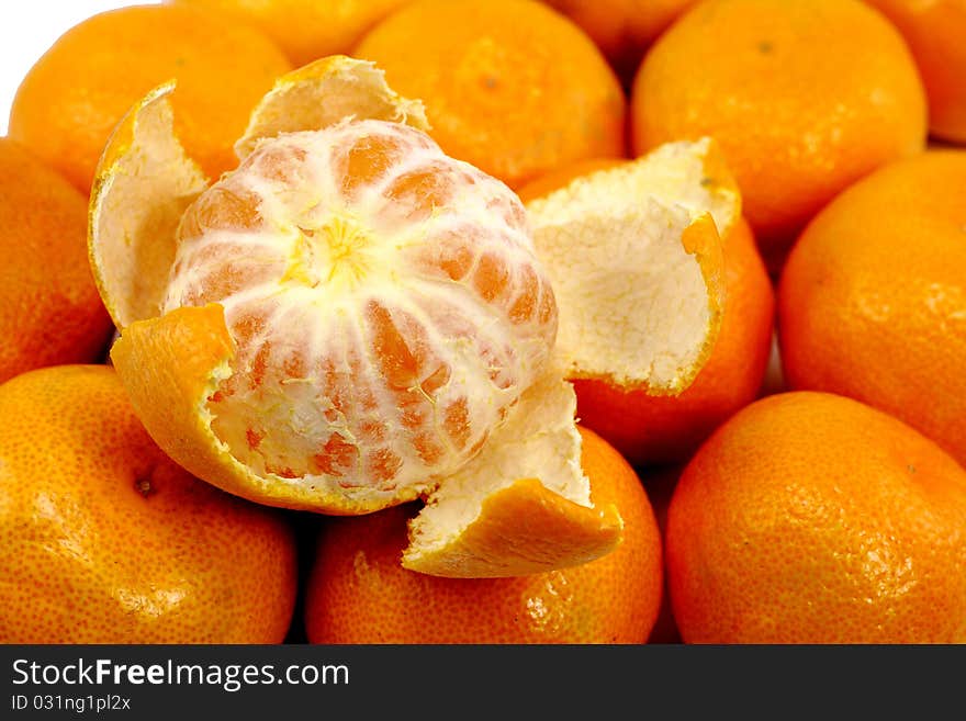 Fresh peeled tangerine on other tangerines