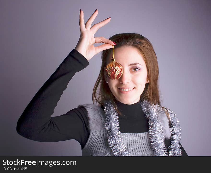 Beautiful girl smiling and holding Christmas decorations in her hand