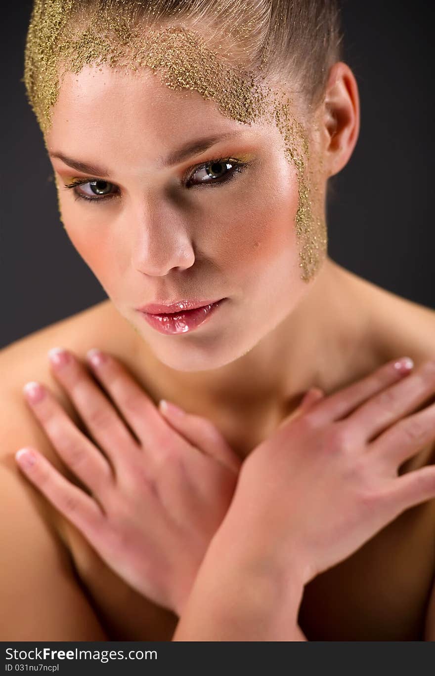 Beautiful young woman with creative make-up isolated on black