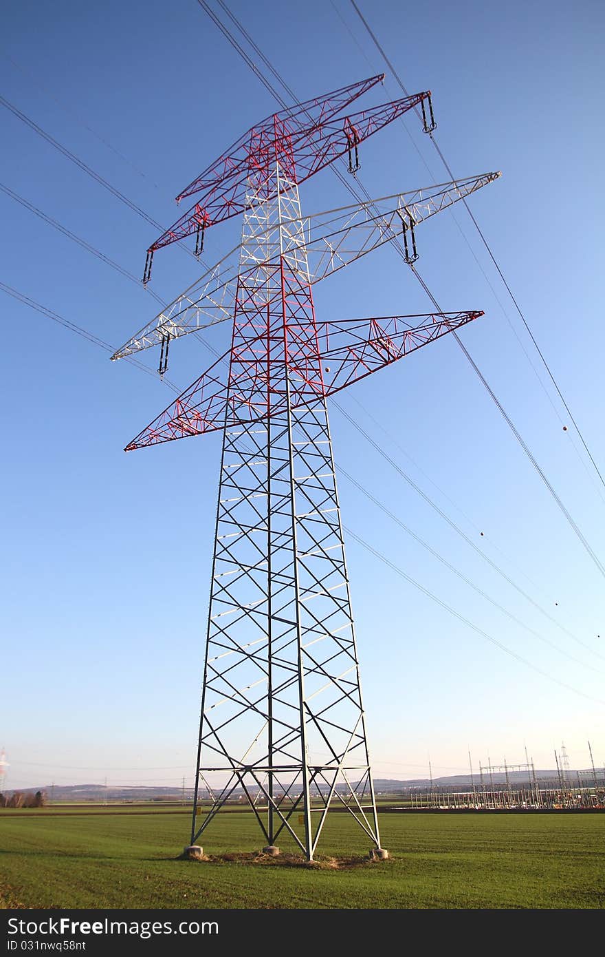 A pylon with power lines in a field