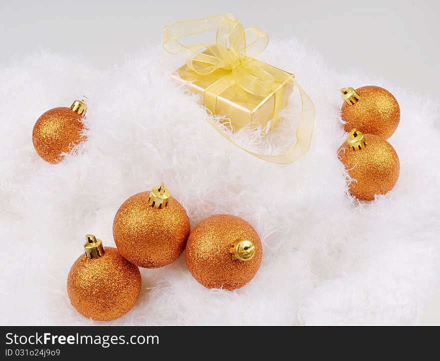 Christmas brightly golden spheres on the white fur