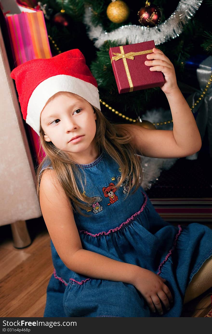 Girl waits gifts. child assorts New Year's gifts