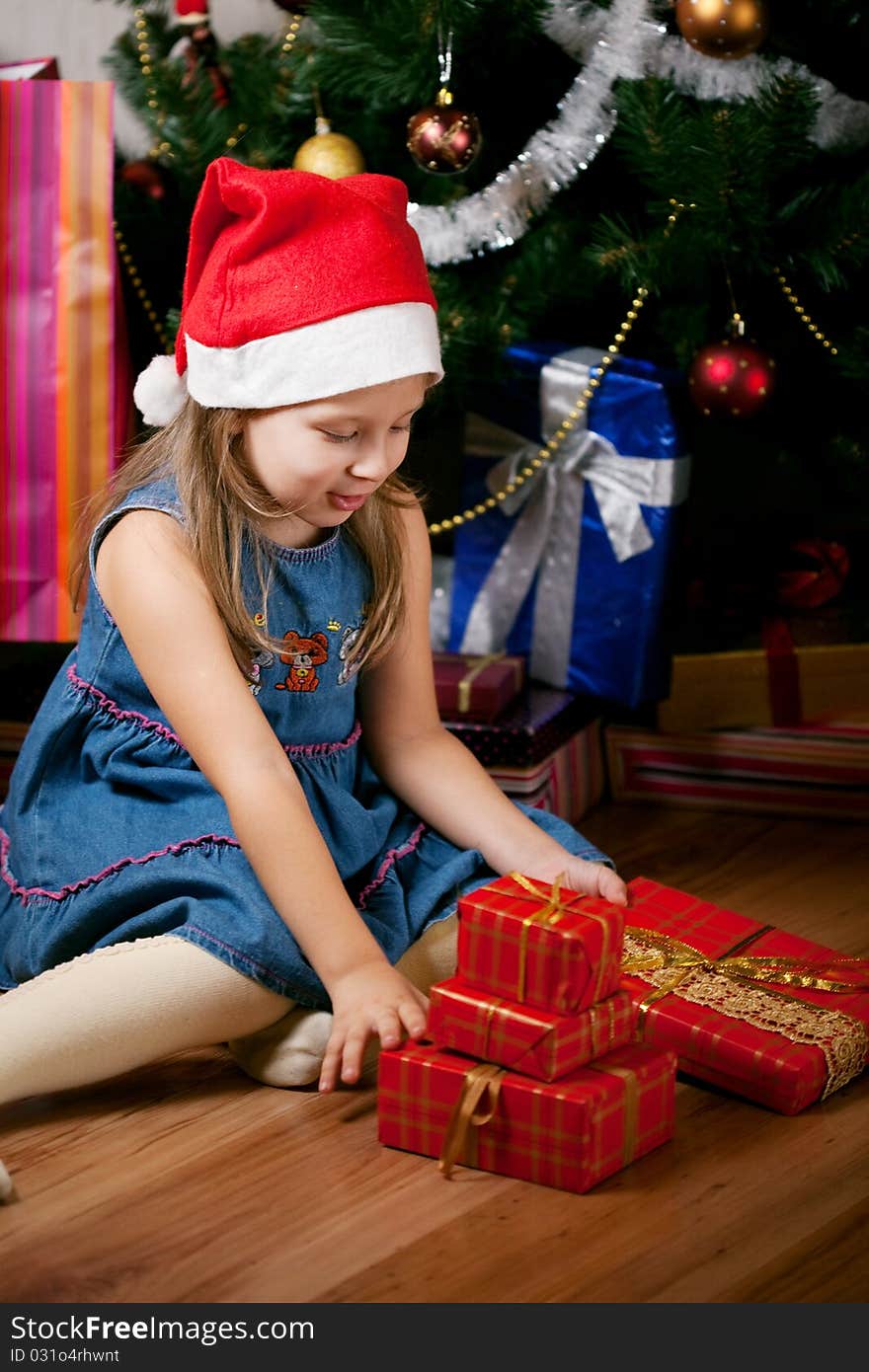 Girl waits gifts. child assorts New Year's gifts