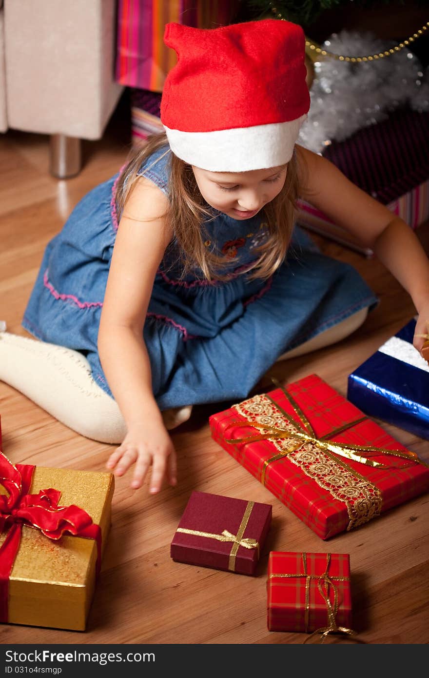 Girl waits gifts. child assorts New Year's gifts