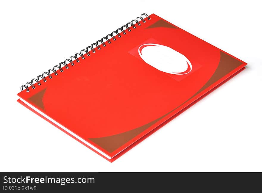 Red rectangular notebook with name label on cover.