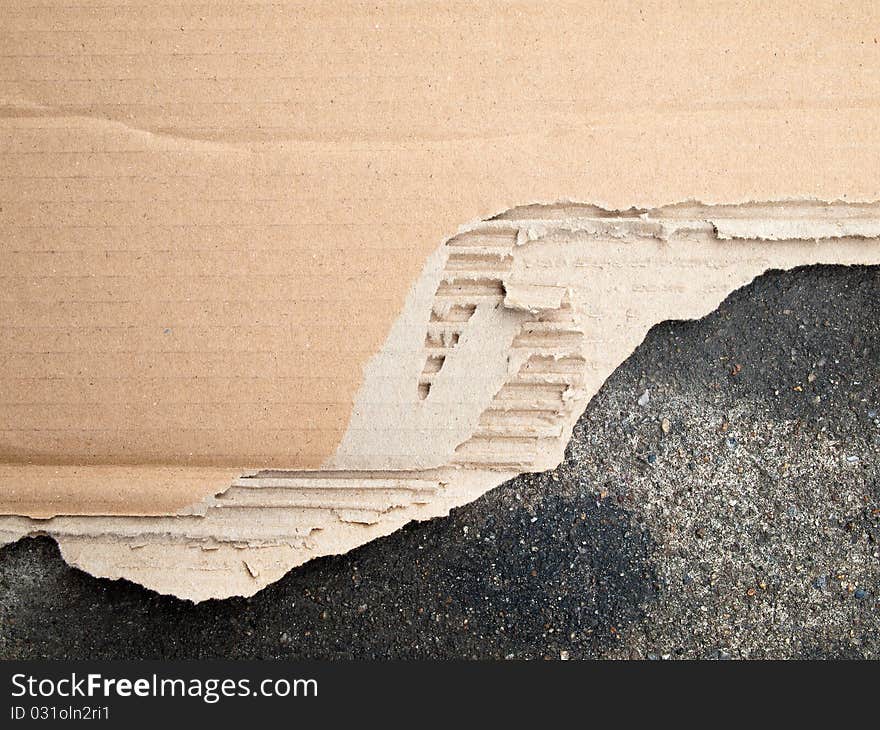 Torn brown cardboard paper on floor