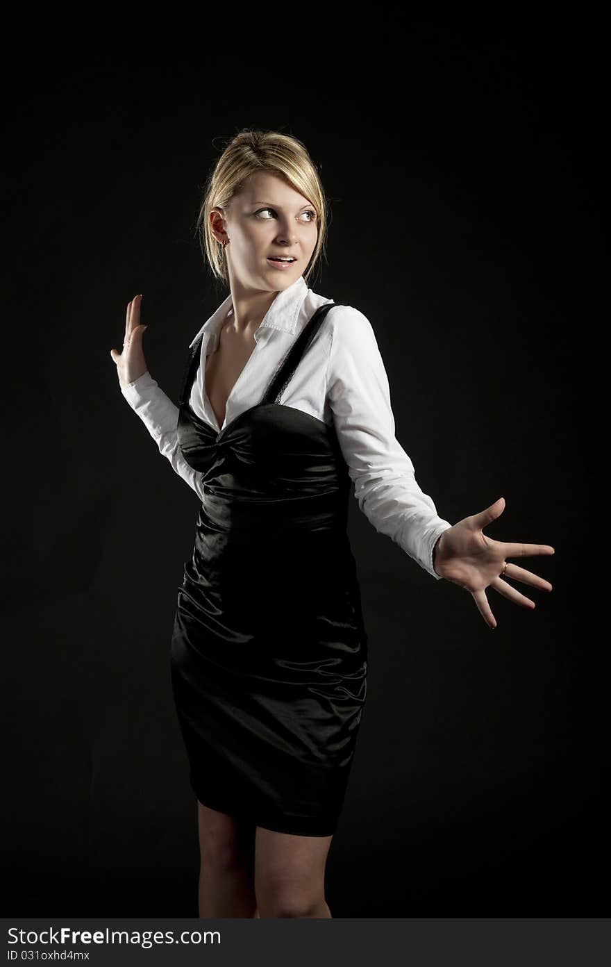 The business woman poses on a black background