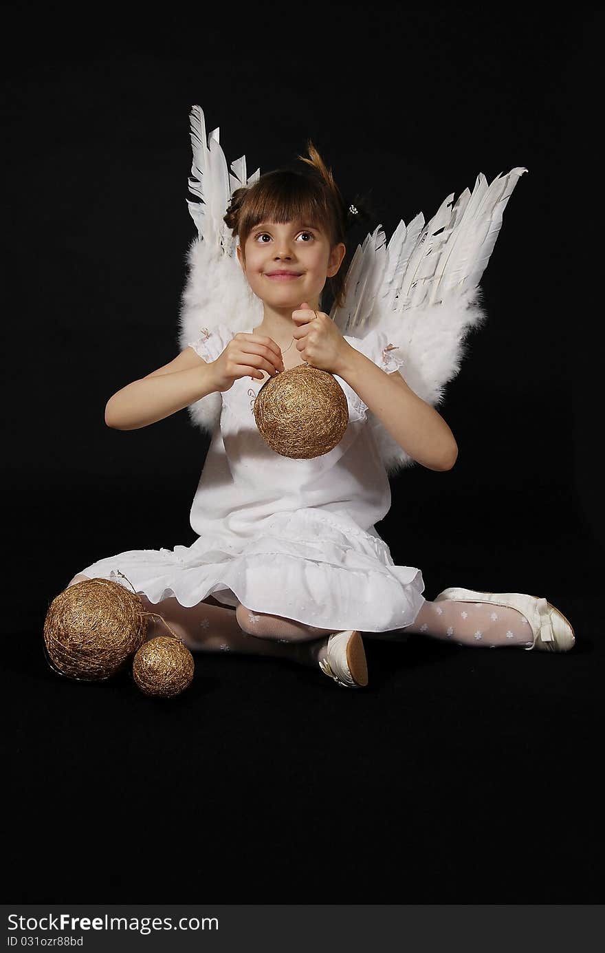 Girl playing with the Christmas glass ball on the black background. Girl playing with the Christmas glass ball on the black background