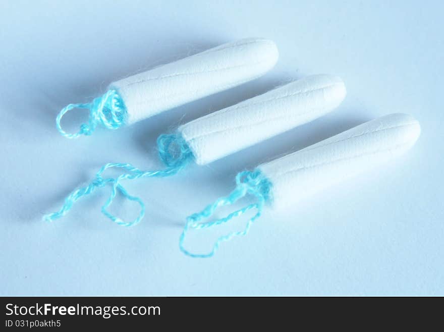 Health care and medicine - white tampons on blue background