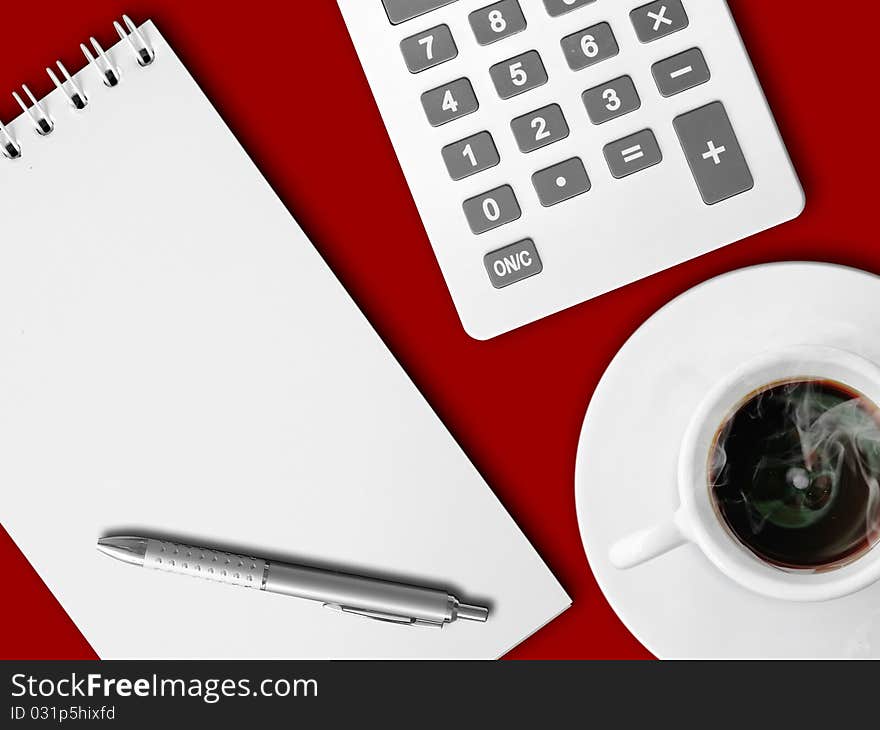 White calculator and white note paper with pen and white cup of hot coffee on red table. White calculator and white note paper with pen and white cup of hot coffee on red table