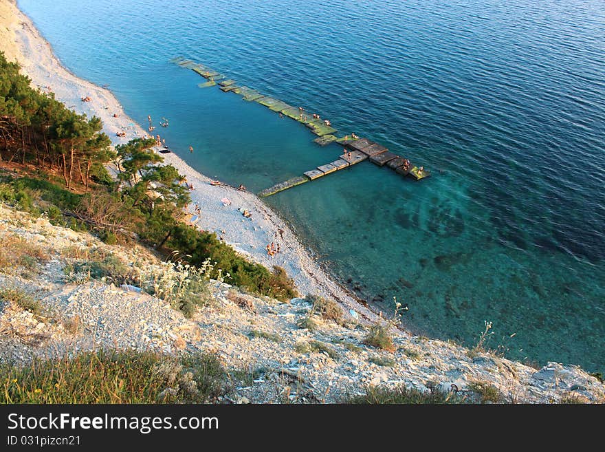 The top view on a wild beach and the azure sea