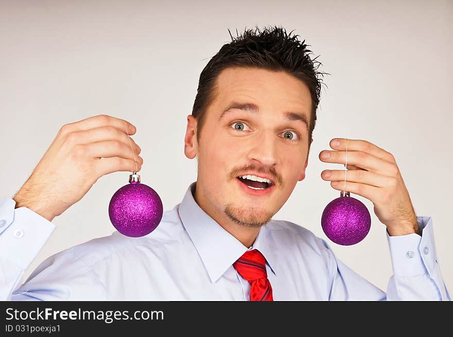 Happy young man in shirt and red tie shows violet Christmas Ornament. Happy young man in shirt and red tie shows violet Christmas Ornament