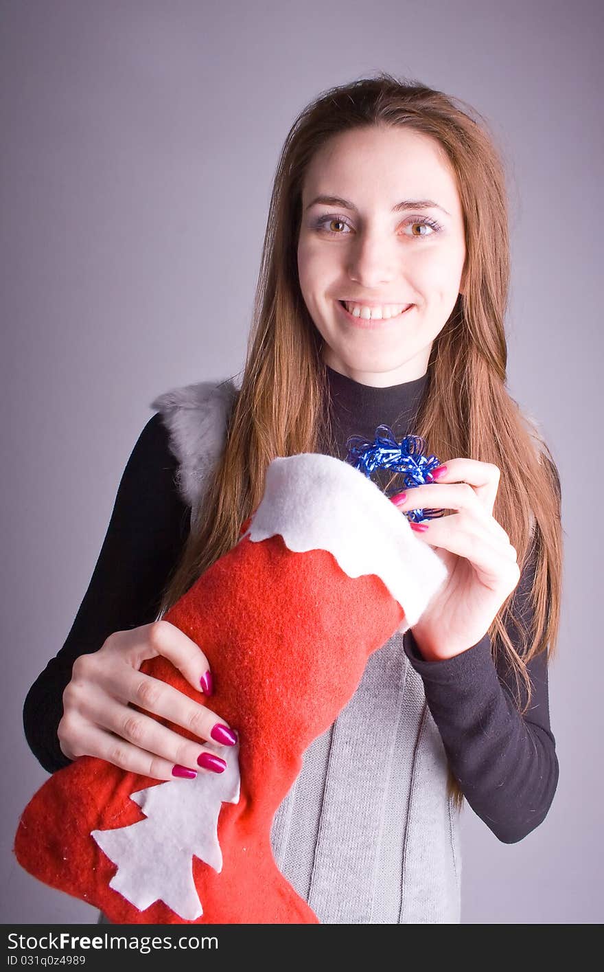 Beautiful girl with a Christmas present smiles