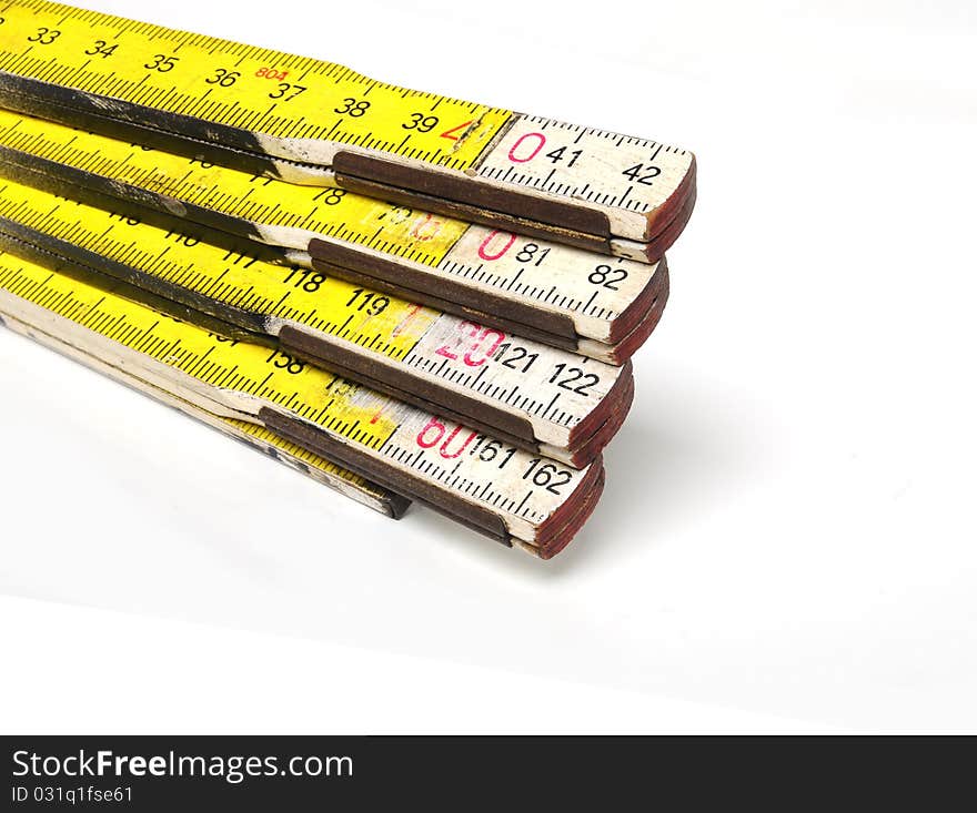 Detail of a yellow and white colored yardstick over white background. Detail of a yellow and white colored yardstick over white background