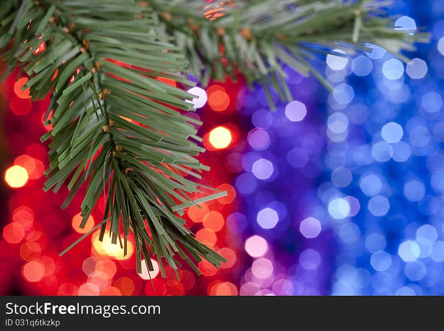 Christmas theme. Motley-colored background with a Christmas tree branch.