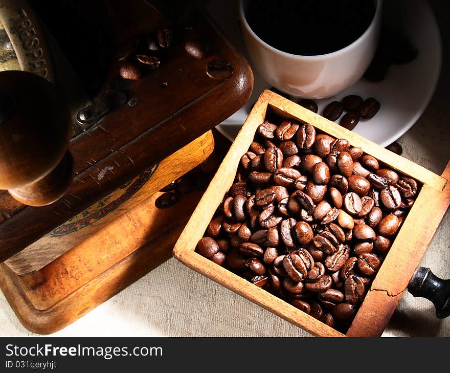 Cup of espresso coffee, old grinder and beans