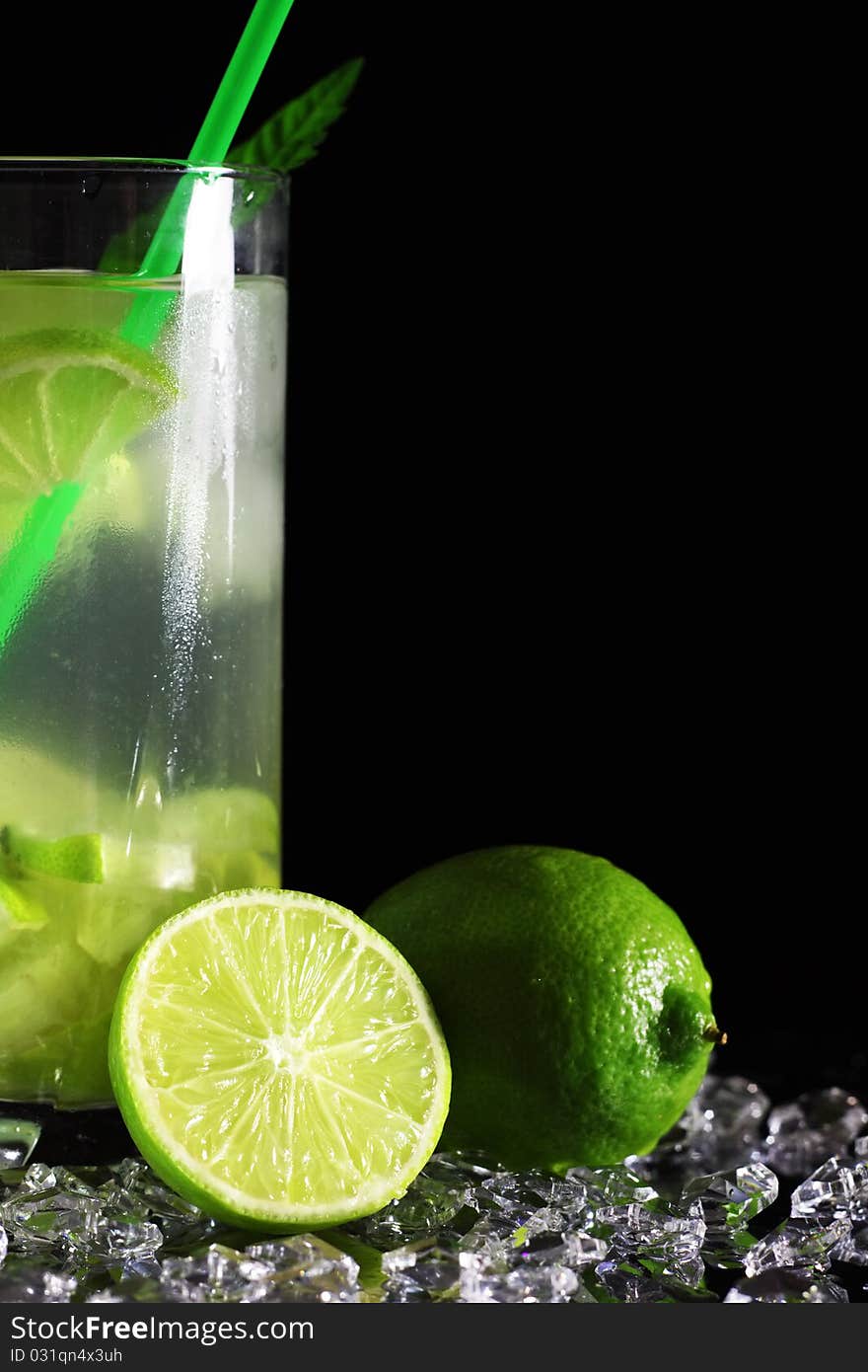 Mojito cocktail with fresh limes on a black background