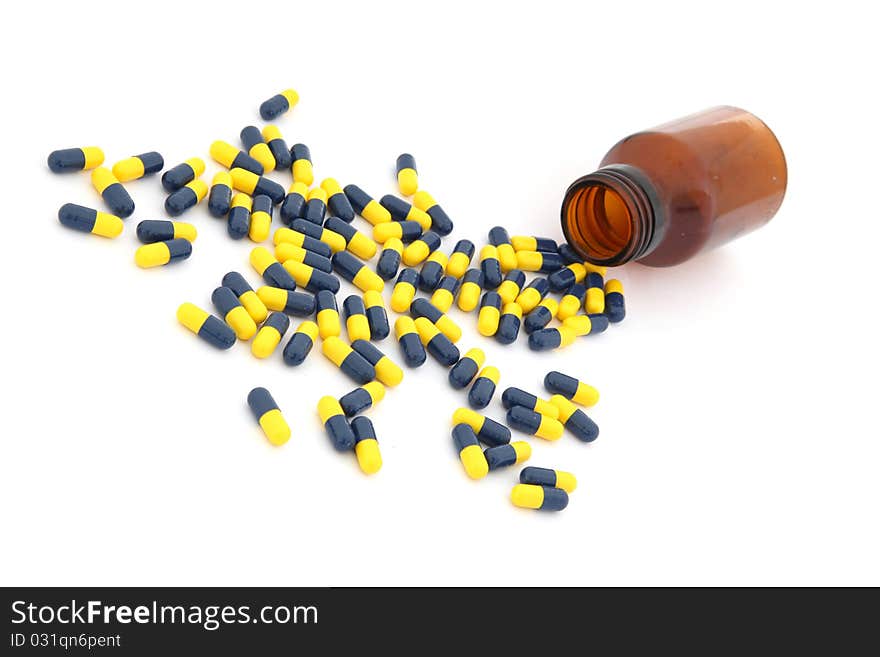 Open pill bottle with capsules spilling out of it isolated on white. Open pill bottle with capsules spilling out of it isolated on white