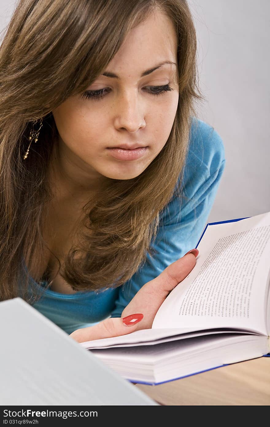 Beautiful girl thoughtfully reading a book