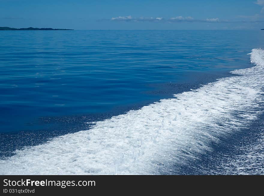 WS: Calm blue sea in tropical Fiji, with a frothy white speedboat wash (wake) filling LR third. WS: Calm blue sea in tropical Fiji, with a frothy white speedboat wash (wake) filling LR third