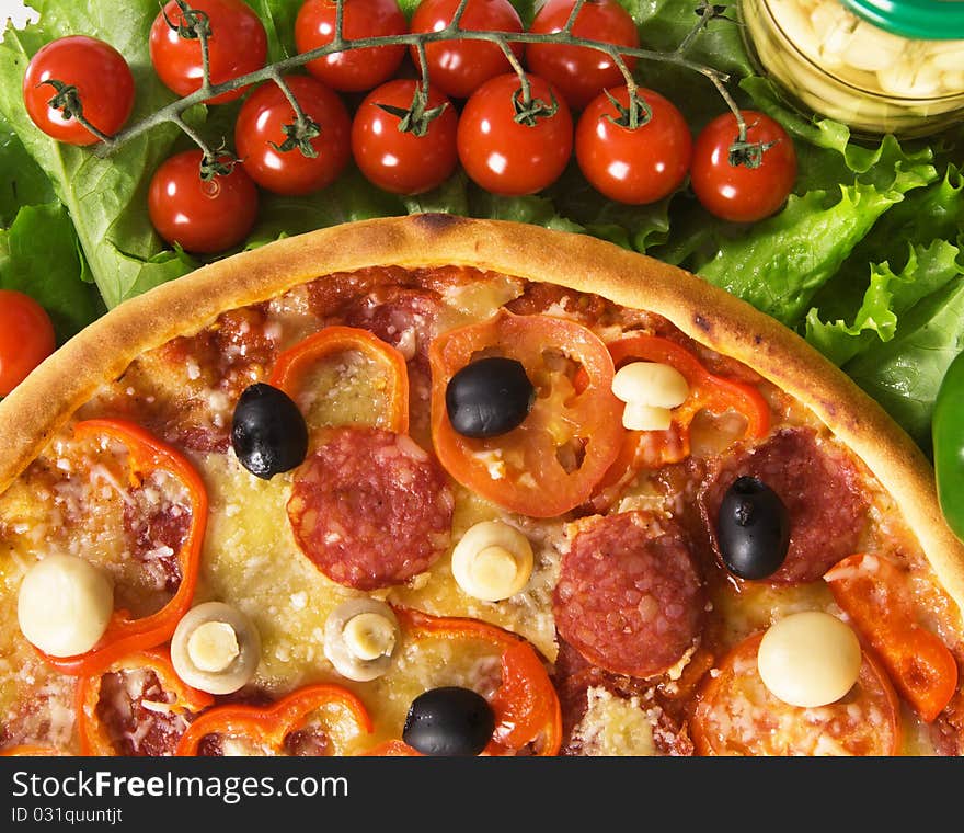 Closeup picture of a pizza with vegetables and cherry tomatoes