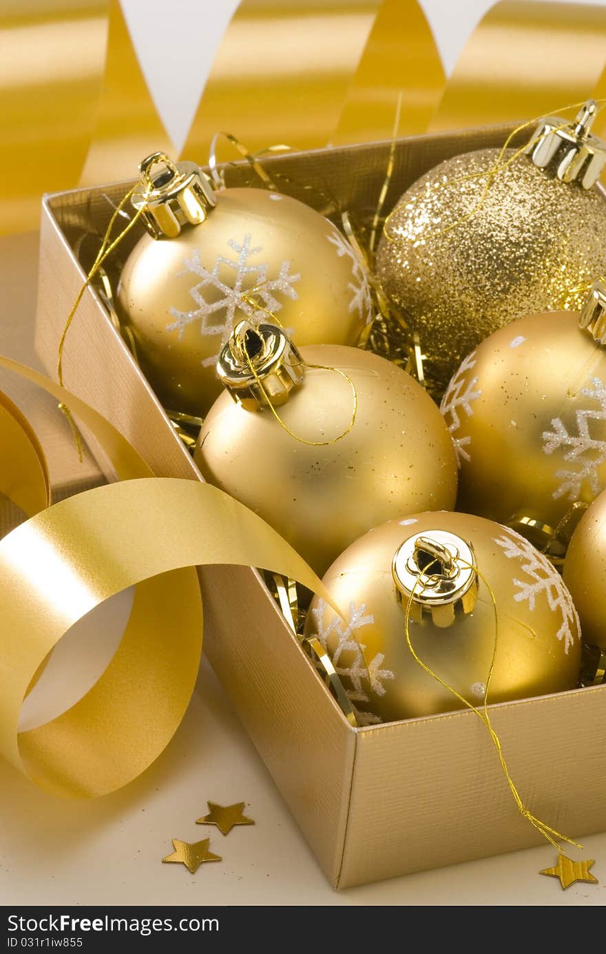 Golden Christmas balls in a gift box.White background. Golden Christmas balls in a gift box.White background.