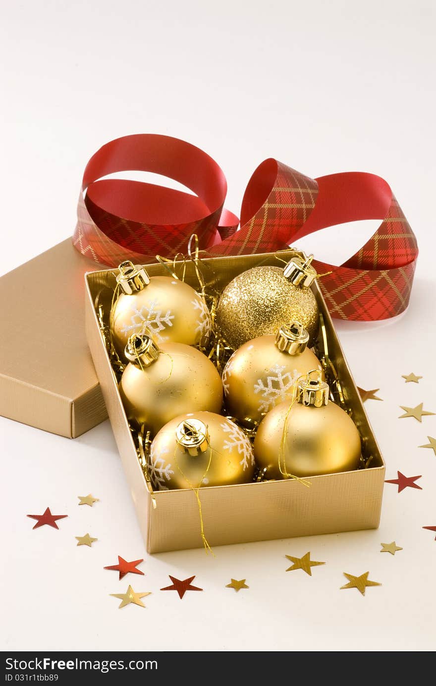 Golden Christmas balls in a gift box.White background. Golden Christmas balls in a gift box.White background.