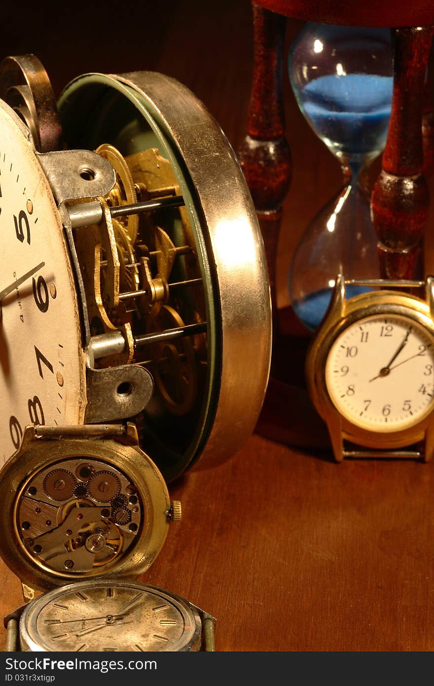 Hourglass, old watch and clock mechanism on wooden background. Hourglass, old watch and clock mechanism on wooden background