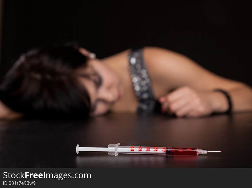 Drug addict woman with is sleeping on table