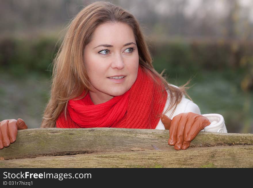 Woman standing by the wooden fence. Woman standing by the wooden fence