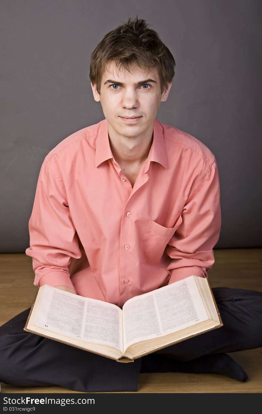 Young boy reading a book on floor