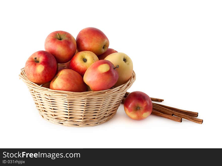 Basket with apples and cinnamon on a white background. Basket with apples and cinnamon on a white background