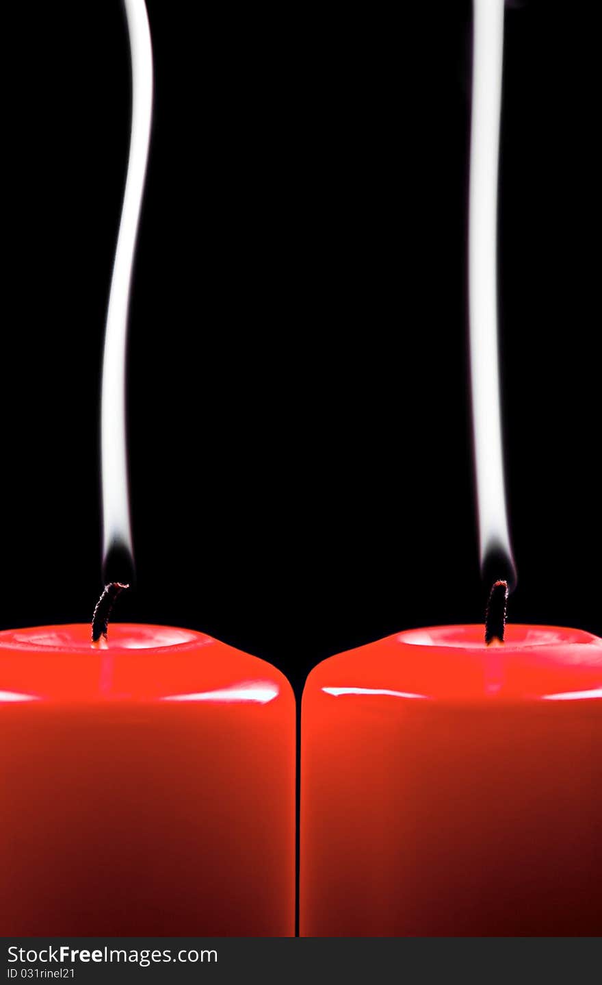 Two red extinct candles on black