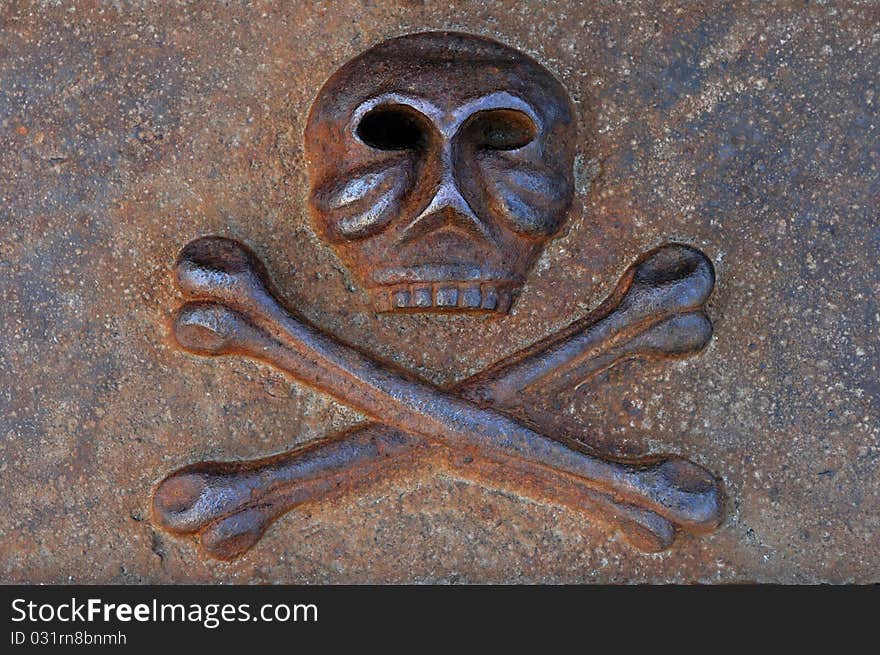 Rusty human skull with crossed bones cast from iron Danger and death symbol. Rusty human skull with crossed bones cast from iron Danger and death symbol