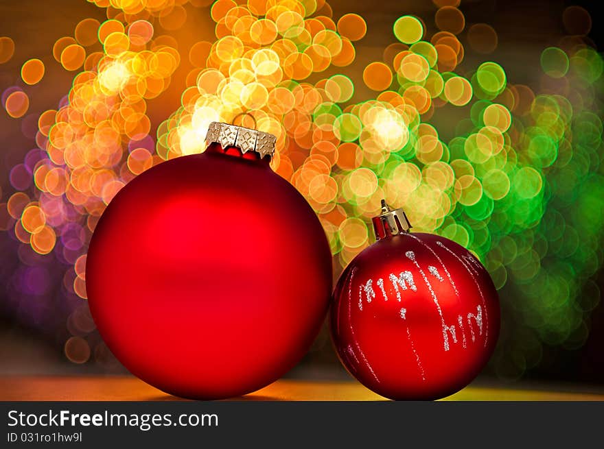 Red Christmas baubles on background of golden lights.