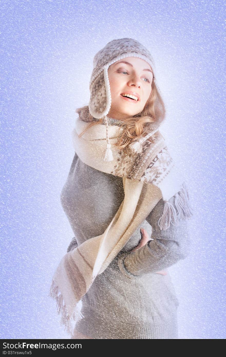 Portrait of a beautiful young woman in winter clothes in the snow